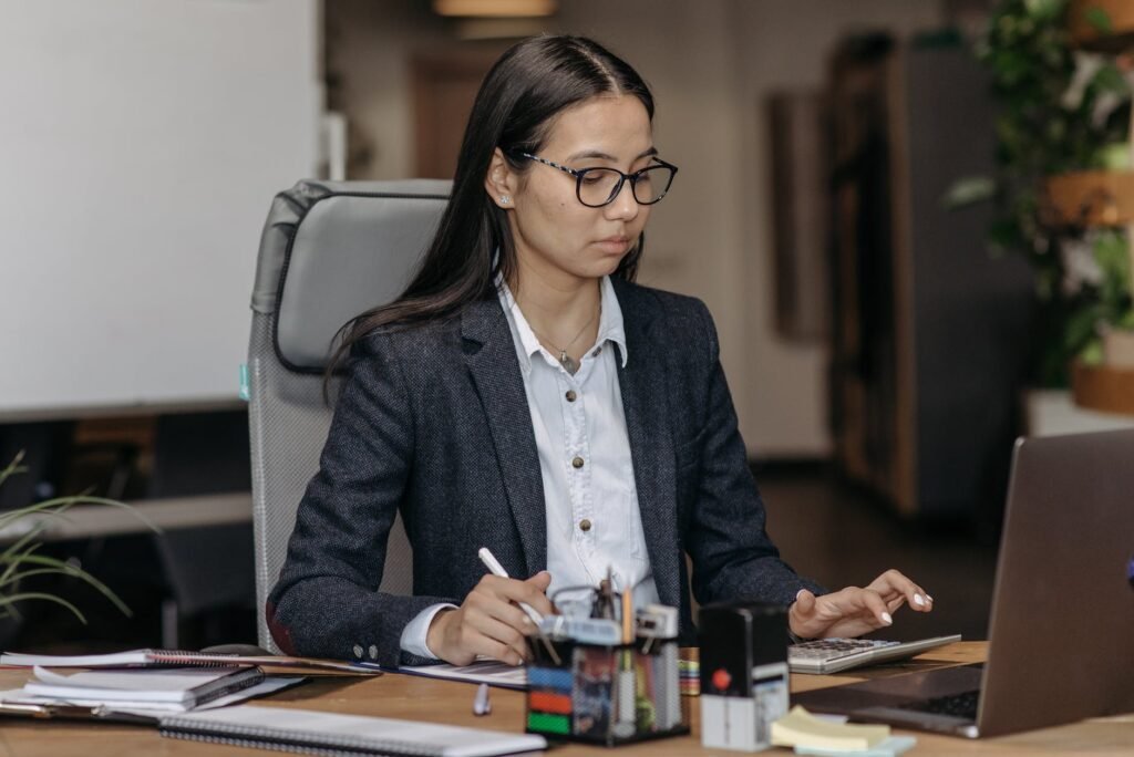 young woman sitting at the desk in an office and working